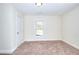 Cozy bedroom featuring neutral walls, carpet, and a window with natural light at 6316 Rockland Rd, Lithonia, GA 30038