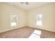 Sunlit bedroom features neutral walls, carpet and two bright windows overlooking the outdoors at 6316 Rockland Rd, Lithonia, GA 30038