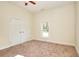 Cozy bedroom features neutral walls, carpet, a bright window, and a closet with double doors at 6316 Rockland Rd, Lithonia, GA 30038