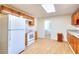 Kitchen with wood cabinets, white appliances, hardwood floors and access to a laundry room at 6316 Rockland Rd, Lithonia, GA 30038
