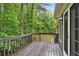 Back deck with wooden railing with views of the green backyard at 1256 Spring Park Sw Dr, Atlanta, GA 30311
