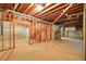 Unfinished basement offering potential with exposed wood beams, cement foundation, and utilities access at 1256 Spring Park Sw Dr, Atlanta, GA 30311