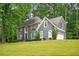 Stylish two-story house with a lush green lawn, mature trees, and a side-entry garage at 1256 Spring Park Sw Dr, Atlanta, GA 30311
