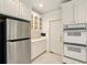 Kitchen boasts white cabinets, stainless steel refrigerator and appliances, and tiled floors at 1256 Spring Park Sw Dr, Atlanta, GA 30311