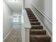 Carpeted staircase with white handrail leads to upper level with view of living area at 1436 Arbor Place Dr, Morrow, GA 30260