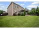 Exterior angle view of the backyard features a screen porch, lush green lawn, and mature trees at 2955 Pleasant Valley Trl, Cumming, GA 30028