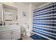 Bright bathroom with a modern vanity, coordinating decor, and a shower with stylish blue and white curtain at 2955 Pleasant Valley Trl, Cumming, GA 30028