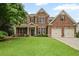 Charming two-story brick home with a lush green lawn and two-car garage at 2955 Pleasant Valley Trl, Cumming, GA 30028