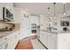 Stylish white kitchen features stainless steel appliances, granite countertops, and ample cabinet space at 2955 Pleasant Valley Trl, Cumming, GA 30028