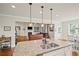 Open kitchen with granite countertops, stainless steel sink, and view into the living room at 2955 Pleasant Valley Trl, Cumming, GA 30028