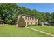 Brick townhome on a lush green lawn with mature trees and a clear blue sky at 373 Dixie Ct, Lawrenceville, GA 30046