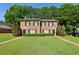 Brick townhome featuring a well-manicured lawn, black shutters, and mature trees in the background at 373 Dixie Ct, Lawrenceville, GA 30046