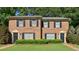 Charming brick townhome with black shutters, green grass, and neatly trimmed bushes at 373 Dixie Ct, Lawrenceville, GA 30046