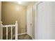 Hallway with carpeted floor, white staircase railing, and closed white doors at 373 Dixie Ct, Lawrenceville, GA 30046