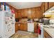 View of a kitchen with wooden cabinets, white appliances, and visible storage solutions at 373 Dixie Ct, Lawrenceville, GA 30046