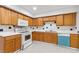 Well-lit kitchen with white countertops, oak cabinets, and modern appliances for a functional cooking space at 1224 Everwood Sw Dr, Marietta, GA 30008