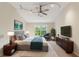 A staged main bedroom featuring a bed, nightstands, artwork, a television, a dresser, and a sitting chair at 1224 Everwood Sw Dr, Marietta, GA 30008