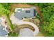 Aerial view of home with pool, stone terrace, luscious landscaping, and circular driveway at 1285 Stuart Rdg, Johns Creek, GA 30022