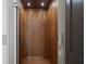Warm wood elevator interior with recessed lighting and safety features. Accessible design promotes ease and independence at 1285 Stuart Rdg, Johns Creek, GA 30022