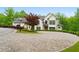 Front of house with a circular driveway, mature landscaping, and a grand entrance at 1285 Stuart Rdg, Johns Creek, GA 30022