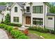 Close up of the beautiful white home with landscaping, front door and chairs at 1285 Stuart Rdg, Johns Creek, GA 30022