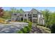 Beautiful white home with black trim, set in a lush green landscape and circular driveway at 1285 Stuart Rdg, Johns Creek, GA 30022