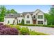 Stunning white exterior with beautiful landscaping and a circular driveway at 1285 Stuart Rdg, Johns Creek, GA 30022