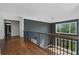 Hallway boasts hardwood floors, black railings, soaring ceilings, and a large window offering bright, natural light at 1285 Stuart Rdg, Johns Creek, GA 30022