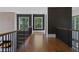 Second-floor hallway featuring hardwood floors, dark accent walls, and wrought iron railings at 1285 Stuart Rdg, Johns Creek, GA 30022