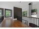 Hallway with hardwood floors, black metal railings, and large windows with natural light at 1285 Stuart Rdg, Johns Creek, GA 30022
