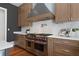 Kitchen featuring high-end stainless steel appliances, custom range hood, and white marble backsplash at 1285 Stuart Rdg, Johns Creek, GA 30022