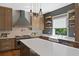 Well-lit kitchen with floating shelves, custom cabinets, stainless steel dishwasher and farmhouse sink at 1285 Stuart Rdg, Johns Creek, GA 30022