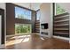 Bright living room with hardwood floors, floor-to-ceiling windows, fireplace, and modern light fixture at 1285 Stuart Rdg, Johns Creek, GA 30022