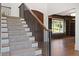 Elegant staircase with carpeted steps, dark wood railings, and an arched doorway at 1285 Stuart Rdg, Johns Creek, GA 30022