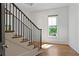 Bright staircase with hardwood steps, black iron railings, and natural light from the window at 1285 Stuart Rdg, Johns Creek, GA 30022