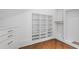 Bright walk-in closet featuring custom built-in shelves, drawers, and hardwood flooring at 1285 Stuart Rdg, Johns Creek, GA 30022