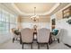 Formal dining room featuring elegant wainscoting, a chandelier, and comfortable seating for six at 1829 Alcovy Shoals Blf, Lawrenceville, GA 30045