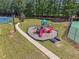 Community playground area featuring a colorful playset with slides and swings, surrounded by grass and trees at 1829 Alcovy Shoals Blf, Lawrenceville, GA 30045