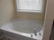 Relaxing soaking tub with a window, offering a bright and airy spa-like experience at 2019 Briar Creek Ne Ct, Conyers, GA 30012