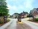 Gated community entrance featuring stone pillars, landscaping, and beautiful homes at 4060 San Marco Way, Douglasville, GA 30135