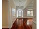 Inviting entryway featuring gleaming hardwood floors, a decorative light fixture, and a view into the living area at 4060 San Marco Way, Douglasville, GA 30135