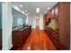 Spacious kitchen featuring dark countertops, dark wood cabinetry, and hardwood floors open to the dining area at 4060 San Marco Way, Douglasville, GA 30135