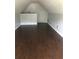 Spacious attic with finished floors, white walls, and a closed white door at 75 Oak Hill Dr, Covington, GA 30016