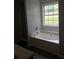Bathroom featuring a tub, shower, and large window, creating a space for relaxation and natural light at 75 Oak Hill Dr, Covington, GA 30016