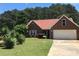 Charming brick home with an attached garage and a well-manicured front yard, nestled beneath a clear blue sky at 75 Oak Hill Dr, Covington, GA 30016