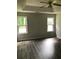 Spacious bedroom featuring a tray ceiling, a ceiling fan, wood-look flooring, and natural light from the windows at 75 Oak Hill Dr, Covington, GA 30016