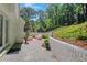 Charming backyard patio featuring a beautiful stone path and a white brick retaining wall with lush greenery at 770 Wellesley Nw Dr, Atlanta, GA 30305