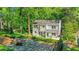 Charming backyard featuring a stone patio and fire pit area surrounded by lush greenery and a well-maintained lawn at 770 Wellesley Nw Dr, Atlanta, GA 30305