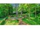 A serene backyard featuring a stone path, lush greenery, mature trees, and a peaceful seating area with a fire pit at 770 Wellesley Nw Dr, Atlanta, GA 30305