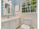 Bathroom features white vanity with quartz counter, framed mirror and a patterned, blue wall at 770 Wellesley Nw Dr, Atlanta, GA 30305